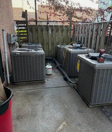 Two outdoor AC condenser units installed on a concrete pad by AFAB Construction
