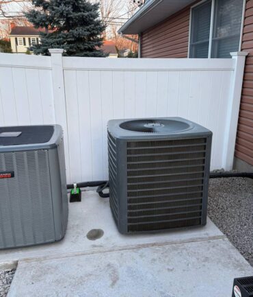 Two AC condenser units installed on concrete pads, NJ